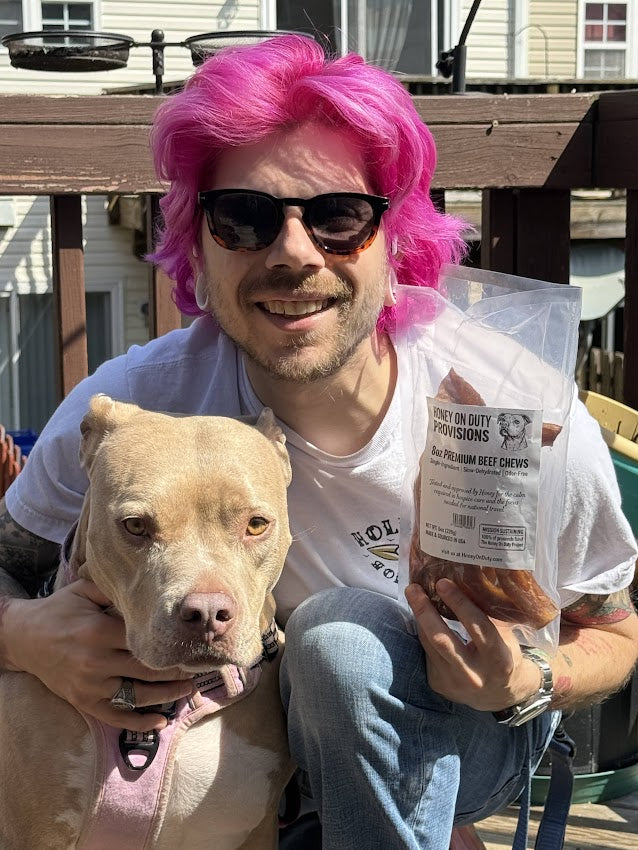 Stefan Walter founder of Honey On Duty holding service dog Honey and a bag of HoneyOnDuty Provisions premium beef chews outdoors